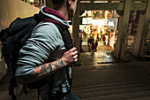 A Male Traveler Looking Towards Retail Shops From The Street; Xiamen, Fujian, China