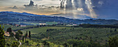 Sonnenstrahlen durch die Wolken über den Weinbergen; Capanuccia, Florenz, Italien