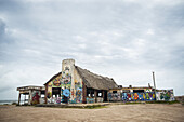 Graffiti, das ein Gebäude am Strand bedeckt; Punta Del Diablo, Uruguay.