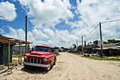 Ein alter roter Lastwagen parkt auf der Sandstraße; Valizas, Uruguay