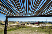 Blick auf den Strand und die Unterkünfte entlang der Küste unter einer Pergola; Cabo Polonio, Uruguay