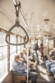 Hängender Griff an der Stange einer Straßenbahn; Mailand, Lombardei, Italien