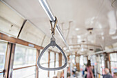 Hängender Griff an der Stange einer Straßenbahn; Mailand, Lombardei, Italien