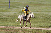 Junge beim Daaga-Pferderennen (zweijährige Pferde) während des mongolischen Nationalfestivals Naadam 2014 in Khui Doloon Khudag, dem Pferderennplatz, Ulan Bator, Mongolei