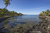 Küstenlinie einer tropischen Insel mit Palmen und strohgedeckten Hütten; Tahiti