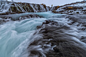 Fotograf, der auf dem Gipfel des Bruarfoss steht und Fotos macht; Island