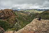 A Woman Sits On A Rock Looking Out Over The Beautiful Landscape Of Toro Toro National Park; Bolivia