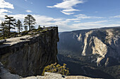 Ein Besucher des Yosemite-Nationalparks steht am Taft Point, der das Yosemite-Tal und El Capitan überblickt; Kalifornien, Vereinigte Staaten von Amerika