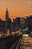 Sonnenuntergang über Sunnyside, Queens mit Empire State Building im Hintergrund (Farben zu Silvester); New York City, New York, Vereinigte Staaten von Amerika