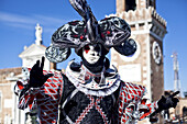 Eine Person in einem verzierten Kostüm und einer Maske; Venedig, Italien.