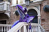 A Woman In A Purple Dress And Fan Posing By A Building And Railing; Venice, Italy