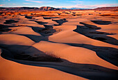 Windverwehter Wüstensand fließt über die Hochebene am Rande der Roten Wüste von Wyoming. Die Killpecker Sanddünen sind eines der größten lebenden Dünensysteme in den Vereinigten Staaten. Das Ökosystem der Hochwüste ist sehr vielfältig und besteht aus Buttes, Salbeibuschsteppe, Bergen und Dünen, die sich in der Landschaft wiederholende Muster bilden; Wyoming, Vereinigte Staaten von Amerika