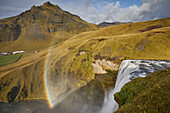 Skogafoss Wasserfall in Südisland mit einem Regenbogen im Nebel; Island