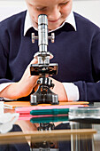Schuljunge schaut in ein Mikroskop