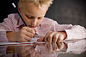 Boy sitting at desk writing