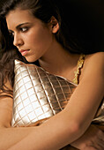 Woman hugging a gold quilted cushion