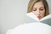 Frau liest ein Buch im Bett