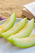 Slices of Melon on white plate
