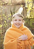 Girl wrapped in a blanket wearing indian feather headdress