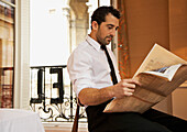 Geschäftsmann im Hotelzimmer liest Zeitung