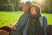 Senior couple sitting side by side in a park