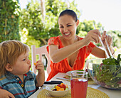 Frau und Kind beim Essen im Freien