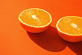 Halbierte Orange auf orangem Hintergrund