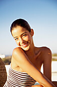 Lächelnde junge Frau in trägerlosem Badeanzug