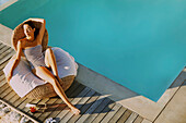 Frau entspannt sich am Swimmingpool, hoher Blickwinkel