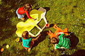 Kinder bemalen Pappausschnitte im Garten