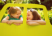 Young Girls Leaning out of Cardboard Car Window