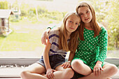 Zwei junge Mädchen auf der Fensterbank sitzend