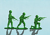 Grünes Soldatenspielzeug auf blauem Hintergrund
