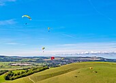 Gleitschirmflieger am Mount Caburn, die über der Grafschaftsstadt Lewes, East Sussex, England, Vereinigtes Königreich, Europa fliegen