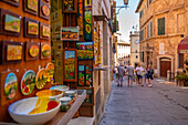 Blick auf Geschäfte und Einkäufer in einer engen Straße in Montepulciano, Montepulciano, Provinz Siena, Toskana, Italien, Europa