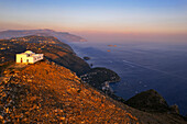 Weiße Kirche San Costanzo auf dem Gipfel eines Berges, der die Amalfiküste bei Sonnenuntergang umgibt, Punta Campanella, Massa Lubrense, Provinz Neapel, Kampanien, Italien, Europa