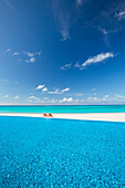 Liegestühle und Infinity-Pool mit Blick auf eine tropische Lagune, Malediven, Indischer Ozean, Asien