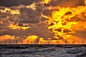 Blick bei Sonnenuntergang von der Insel Walney über die Irische See auf den entfernten Offshore-Windpark Walney, Küste von Cumbria, Cumbria, England, Vereinigtes Königreich, Europa