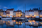 Colourful buildings and tall masted boats on the waterfront at Nyhavn at dusk, Nyhavn Canal, Nyhavn, Copenhagen, Denmark, Europe