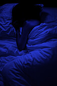 Schlafende Person im Bett bei Dunkelheit