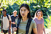Young adult woman looking at the camera while hiking with friends