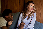Upset woman looking up with crossed arms while arguing with boyfriend