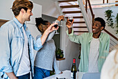 Group of friends toasting with wineglasses while hanging indoors