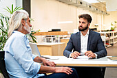 Männlicher Anwalt bei einer Besprechung mit einem Klienten im Büro
