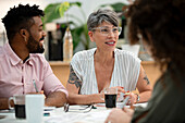 African American businessman discussing over paperwork with coworkers