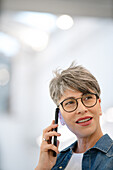 Female entrepreneur listening voice mail on smart phone