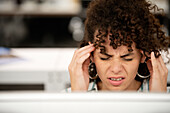 Businesswoman with hands on fronthead having a headache