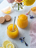 Lemon curd in glasses, decorated with spring flowers and pastel colours