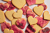 Stamped Heart Cut-Out Cookies with Pink Sugar on a Pink Marble Background