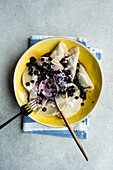 Tasty traditional Ukrainian dumplings with blueberry and sour cream